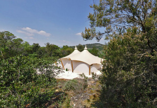 Tienda safari RoyalLodge entre árboles en Slow Village Provence Occitane, bajo cielo azul en Francia.