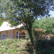 Safari-teltet RoyalLodge ved Slow Village Provence Occitane i Frankrig, delvist skjult af træer og buske.