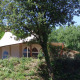 Safari-teltet RoyalLodge ved Slow Village Provence Occitane i Frankrig, delvist skjult af træer og buske.