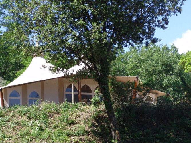 Tienda safari RoyalLodge en Slow Village Provence Occitane, Francia, parcialmente oculta entre los árboles.