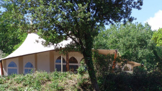 Tienda safari RoyalLodge en Slow Village Provence Occitane, Francia, parcialmente oculta entre los árboles.