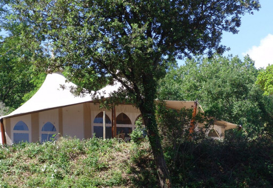 Tienda safari RoyalLodge en Slow Village Provence Occitane, Francia, parcialmente oculta entre los árboles.