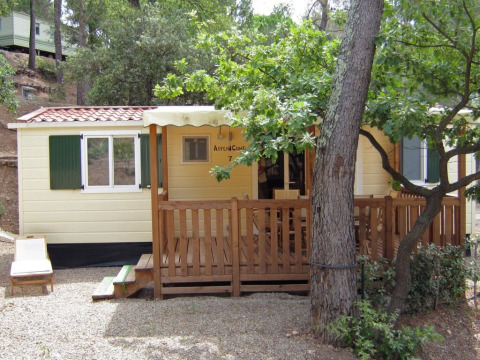 Photo of SunLodge Aspen Combi, a charming cabin with porch, nestled among trees in a peaceful setting.