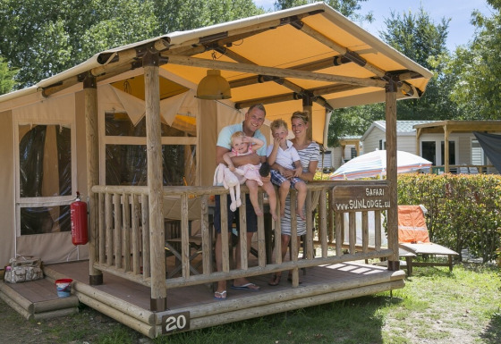 Famiglia sul portico della SunLodge Safari presso il Camping Pra'delle Torri in Italia.
