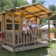 Family enjoying vacation on the porch of a SunLodge Safari at Camping Pra'delle Torri in Italy.