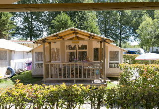 A SunLodge Safari cabin at Camping Pra'delle Torri in Italy, surrounded by greenery and outdoor ambiance.