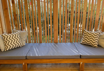 Banc extérieur avec coussins gris à SunLodge Sabai du Camping Gasparina, en Italie.