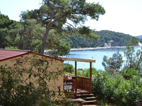SunLodge Aspen, rodeada de árboles, con una vista panorámica al mar y colinas verdes detrás.