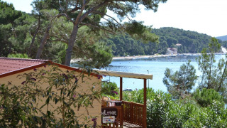 SunLodge Aspen, rodeada de árboles, con una vista panorámica al mar y colinas verdes detrás.