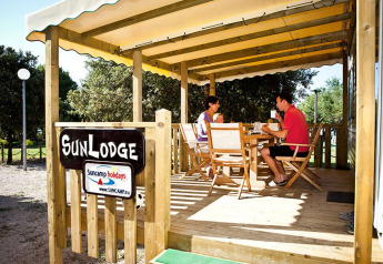 Famiglia che mangia su terrazza in legno sotto tettoia al SunLodge Aspen, Camping Village Poljana, Croazia.