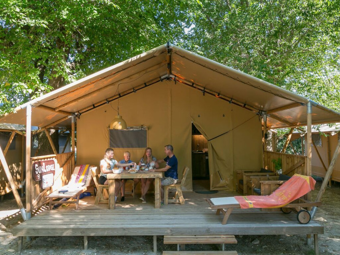 Cuatro personas disfrutan de una comida frente a una tienda SunLodge Bintulu en Camping Village Poljana, Croacia.