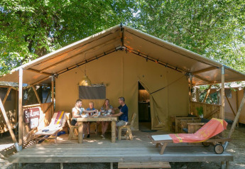 Quatre personnes partagent un repas devant une tente SunLodge Bintulu au Camping Village Poljana en Croatie.