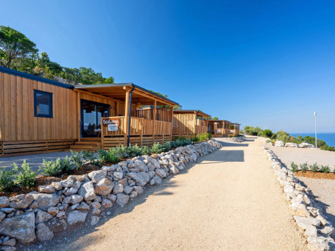 Zonnige houten lodges bij SunLodge Catalpa in Camping Village Poljana, Kroatië, met uitzicht op zee.