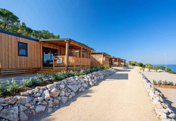 Zonnige houten lodges bij SunLodge Catalpa in Camping Village Poljana, Kroatië, met uitzicht op zee.