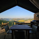 Área de comedor exterior en tienda safari con vistas a colinas en un alojamiento glamping pintoresco.