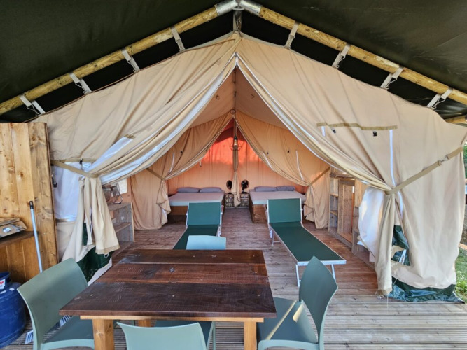 Binnenaanzicht van een safaritentlodge bij Agricola La Casetta in Italië met bedden en eetruimte.