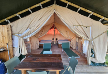 Vue intérieure d’une tente safari à Agricola La Casetta en Italie, avec lits et coin repas.