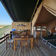 Safari telt glamping indkvartering med træterrasse, spisebord, liggestole og udsigt til naturen.
