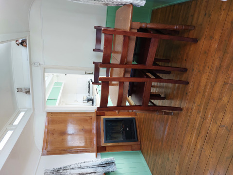 Interior de una cabaña en Pipowagen Snuf, Camping De Gouwe Stek, Países Bajos, con suelo y muebles de madera.