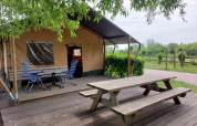 Mesa de picnic y sillas frente a la tienda safari Ekster en Camping De Gouwe Stek, Países Bajos.