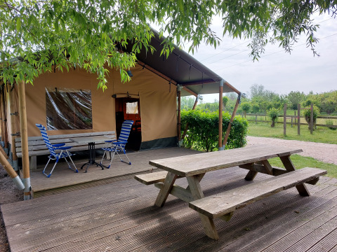 Mesa de picnic y sillas frente a la tienda safari Ekster en Camping De Gouwe Stek, Países Bajos.