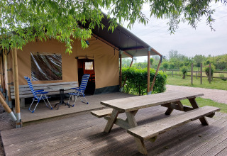 Mesa de picnic y sillas frente a la tienda safari Ekster en Camping De Gouwe Stek, Países Bajos.