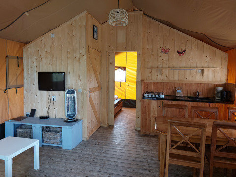 Interior de la tienda Glamping Safari Ekster en Camping De Gouwe Stek, con decoración de madera y comodidades.