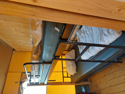 Foto de literas dentro de una tienda glamping safari en Camping De Gouwe Stek en los Países Bajos.