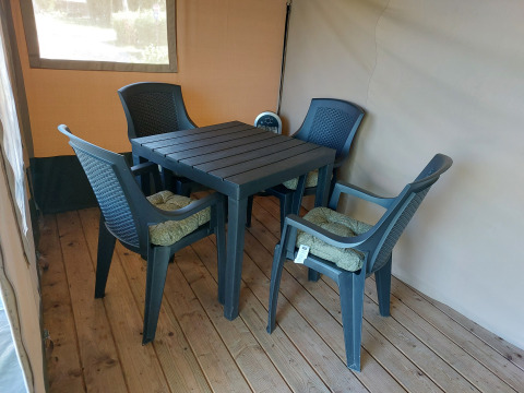 Coin salon extérieur avec quatre chaises en plastique et une table, Safari tent Merel, Camping De Gouwe Stek, Pays-Bas.