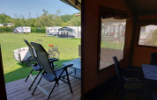 Vista desde la tienda Safari Merel en Camping De Gouwe Stek en Países Bajos, con caravanas y bicicleta.