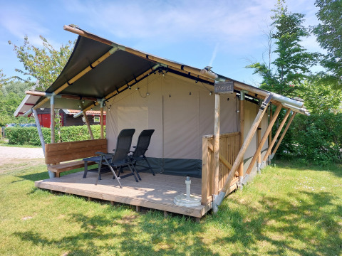 Tienda Safari Merel con terraza en Camping De Gouwe Stek, Países Bajos, bajo un cielo soleado.
