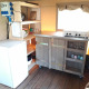 Piccolo angolo cottura con fornello, frigo e scaffali nella Safari tent Merel al Camping De Gouwe Stek.