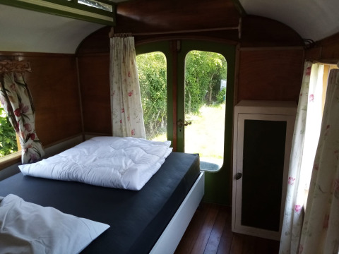 Vista interior de una acogedora habitación en Glamping Pipowagen Klukkluk en Camping De Gouwe Stek en Países Bajos.