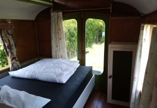 Vista interior de una acogedora habitación en Glamping Pipowagen Klukkluk en Camping De Gouwe Stek en Países Bajos.