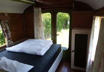 Vista interior de una acogedora habitación en Glamping Pipowagen Klukkluk en Camping De Gouwe Stek en Países Bajos.