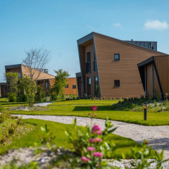 Village vacances moderne abritant des lodges glamping au design original, entouré d’allées et de verdure.