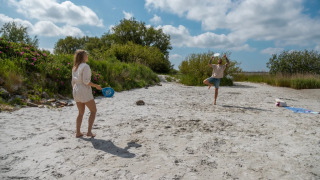Deux personnes jouent au tennis de plage dans un parc de vacances proposant des hébergements glamping.