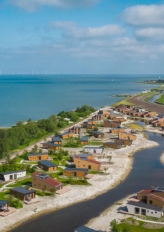 Parc de vacances avec hébergements glamping au bord d’un lac, entouré de verdure et de nature.