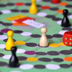 Jeu de société avec des pions colorés et un dé rouge sur le plateau, parfait pour une soirée jeux.