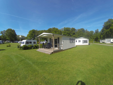 Cabaña luminosa con terraza en Camping Roland, Países Bajos, en un camping verde rodeado de naturaleza.