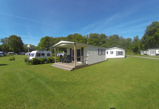 Chalet luminoso con veranda coperta al Camping Roland nei Paesi Bassi, immerso in uno spazio verde.