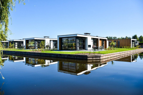 Lodges modernos junto al agua en Villa Nautica, MarinaPark Residentie Nieuw Loosdrecht, Países Bajos, día soleado.