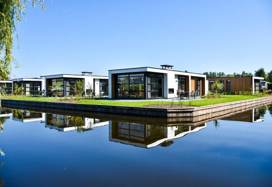 Lodges modernos junto al agua en Villa Nautica, MarinaPark Residentie Nieuw Loosdrecht, Países Bajos, día soleado.