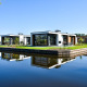 Moderne lodges ved vandet på Villa Nautica, MarinaPark Residentie Nieuw Loosdrecht, Holland, under en blå himmel.