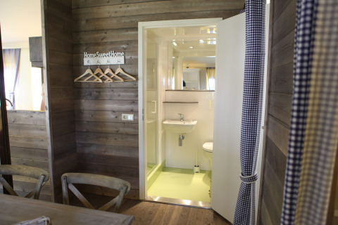 Foto interior de una acogedora cabaña en Vakwerktent, Camping Roland en los Países Bajos, con paredes de madera.