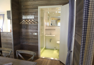 Foto interior de una acogedora cabaña en Vakwerktent, Camping Roland en los Países Bajos, con paredes de madera.