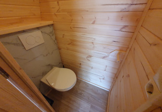 Baño moderno en una tiny house de paneles de madera, Pod en Camping Roland, Países Bajos.