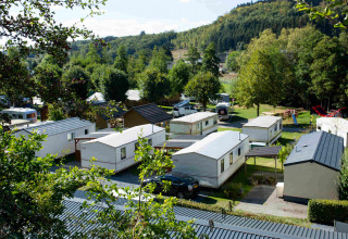 Udsigt over campingområdet Camping Val d'Or i Wiltz, Luxembourg, omgivet af grønne træer og bakker.