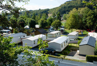 Overview of Camping Val d'Or holiday park in Wiltz, Luxembourg, with mobile homes and lush green scenery.