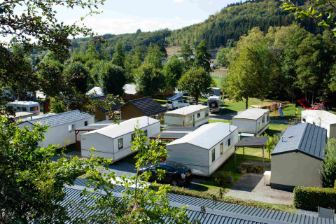 Blik op Camping Val d'Or in Wiltz, Luxemburg, met mobilhomes omgeven door een groene omgeving.